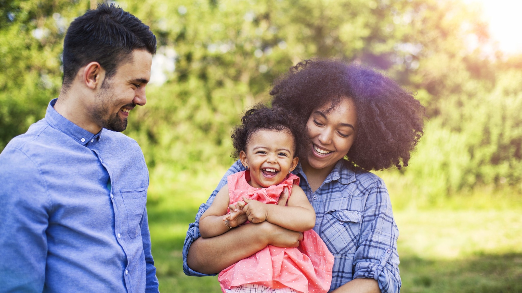 Multiracial adults with young child outside