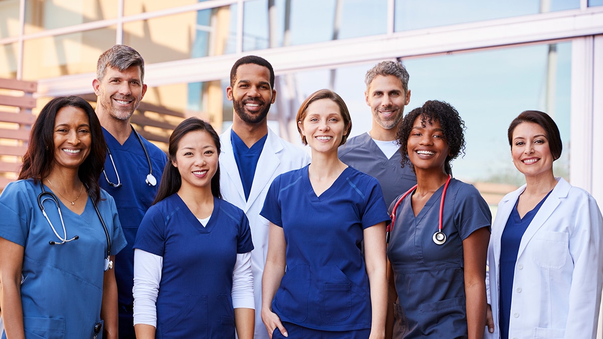 Group of healthcare providers of different ages and races standing together