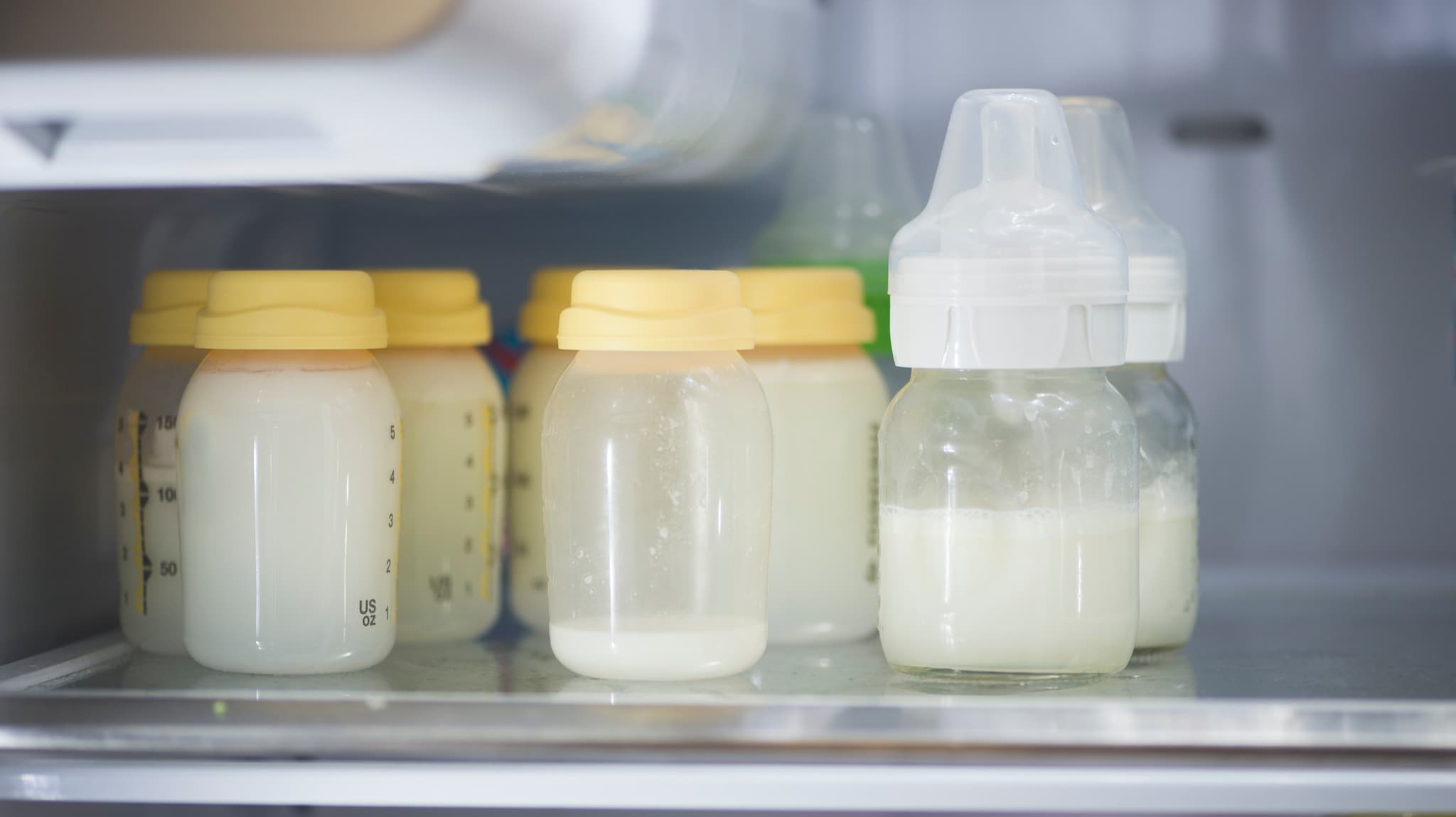 Pumped breast milk in storage containers inside of a refrigerator