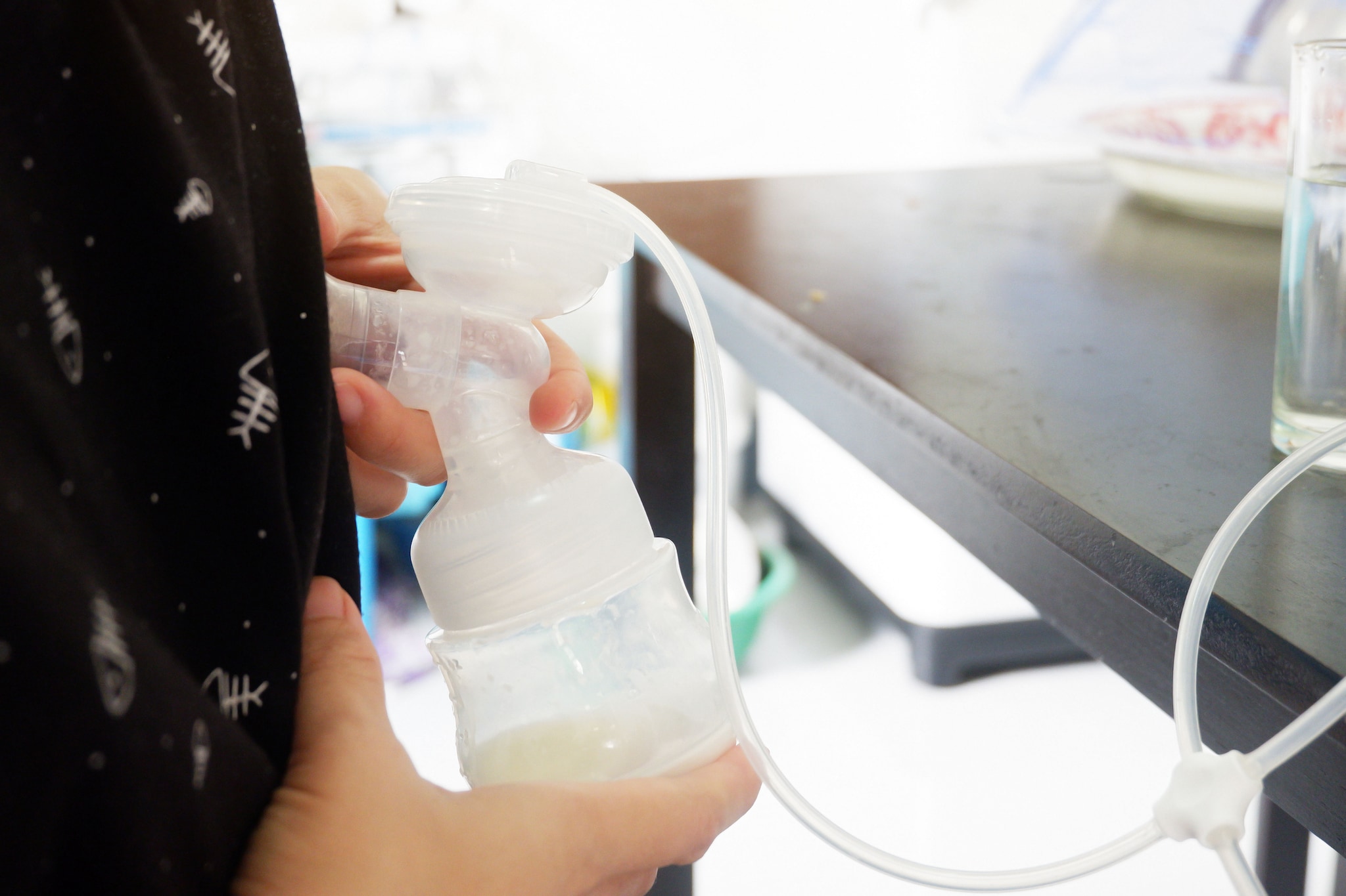 A woman expressing breast milk using a breast pump