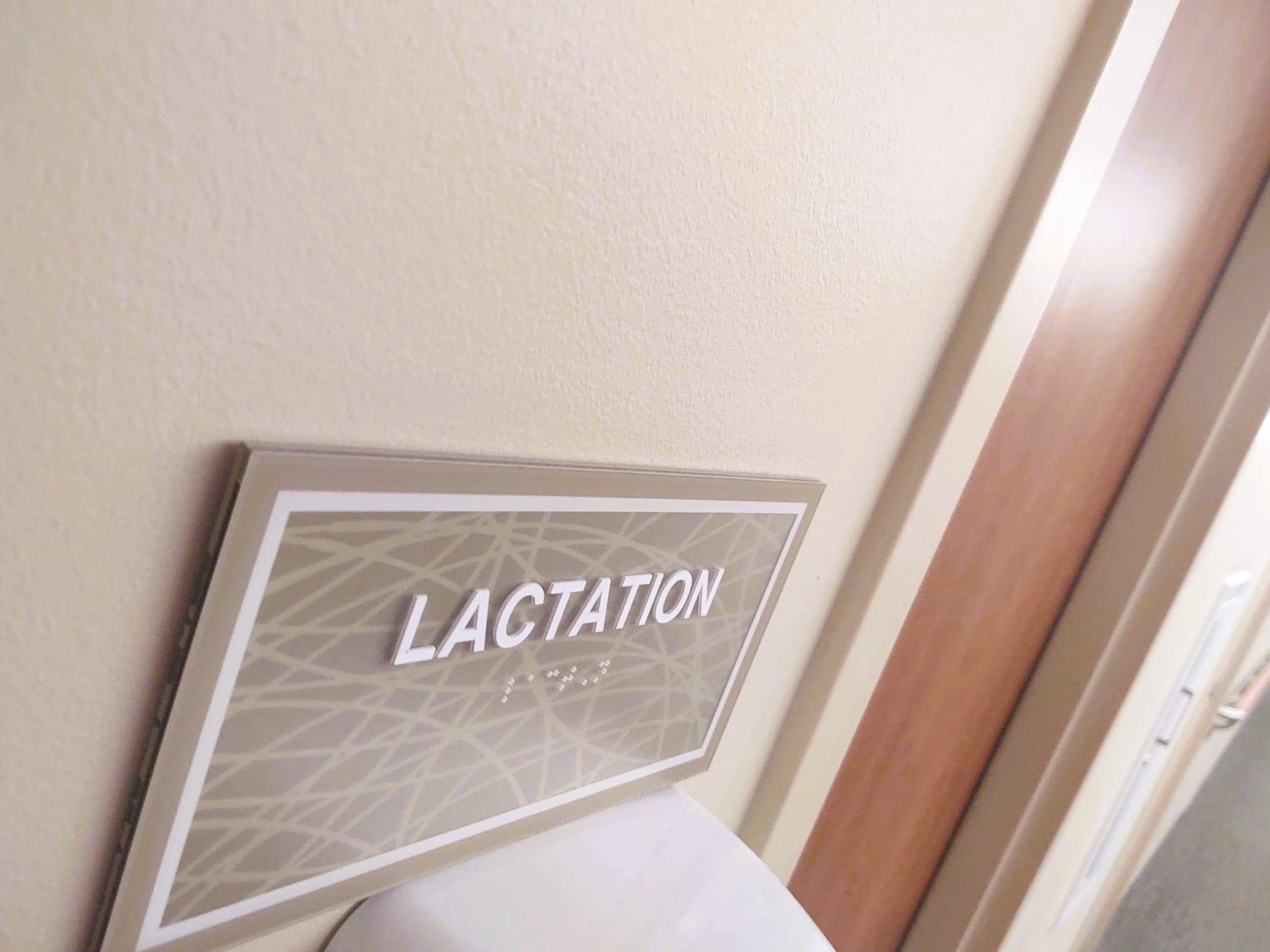 Sign on a wall outside of a door that reads "Lactation"