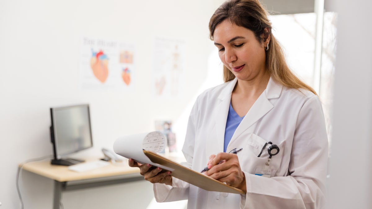 Clinician taking notes on a clipboard in healthcare setting