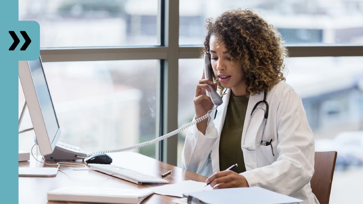 Doctor holding phone and taking notes.