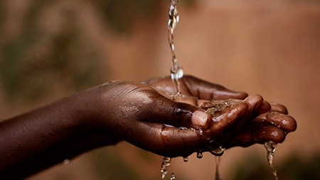 Water flows through cupped hands.