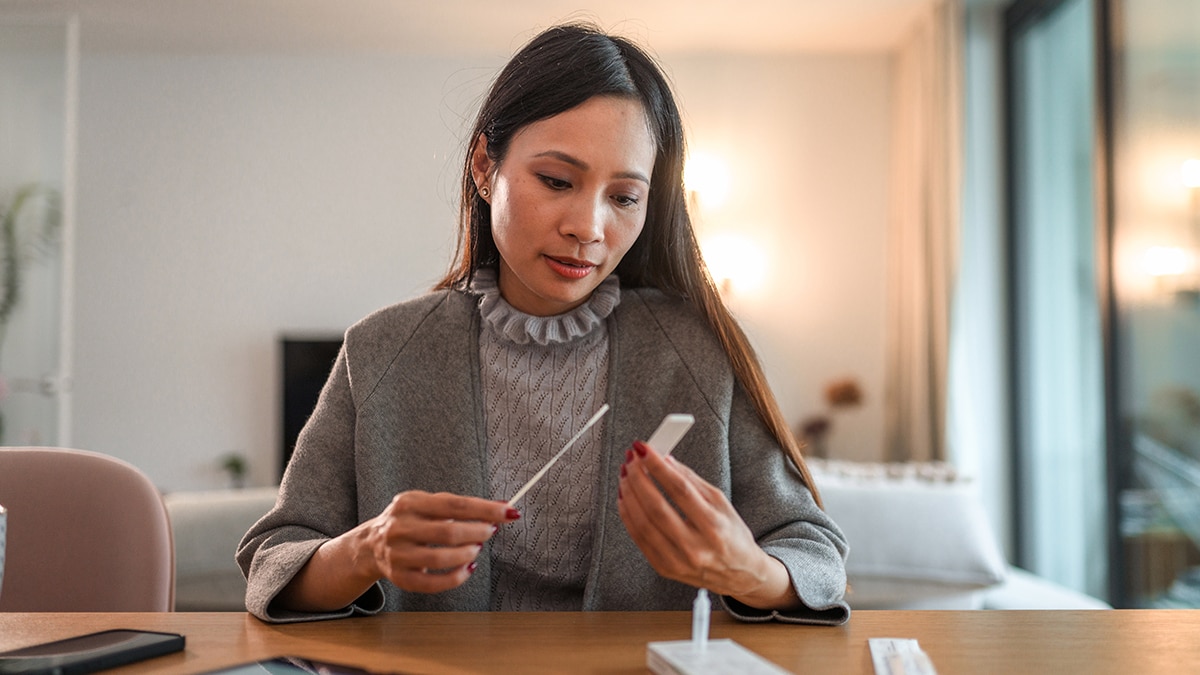 Asian woman holding covid rapid test and waiting for results