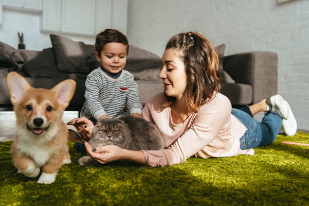 A woman and child sitting on the floor with a dog.