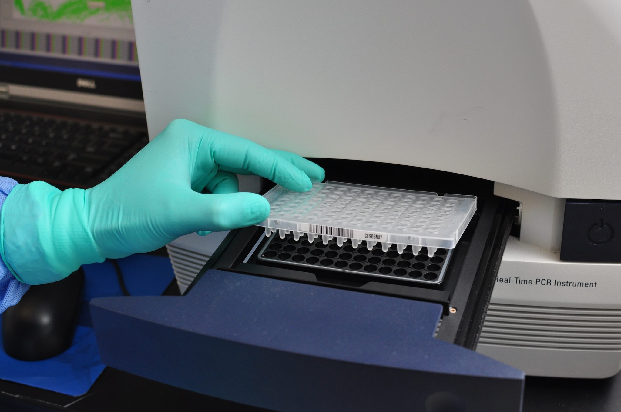 An image of a technician loading a test tray into a machine.