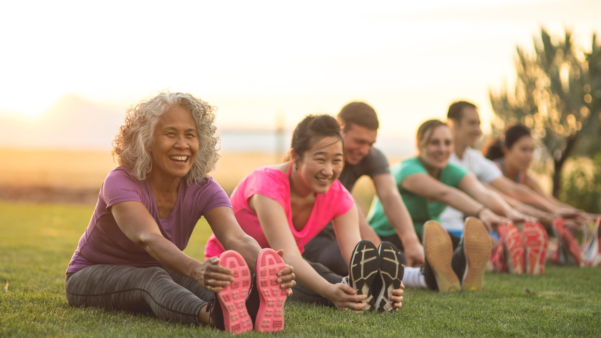 Diverse group of people stretching outside