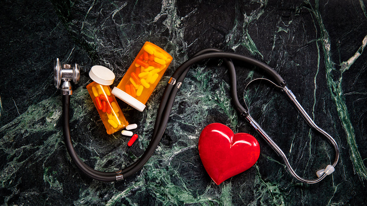 medicine and stethoscope on green marble background