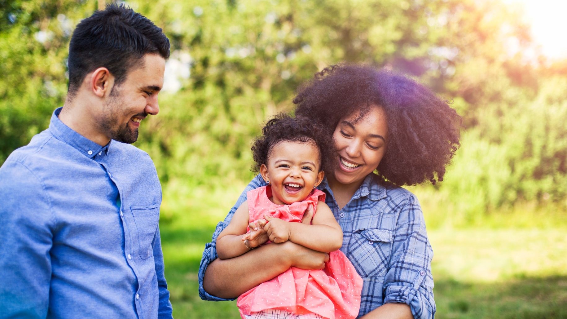 Two adults outside with a young child.