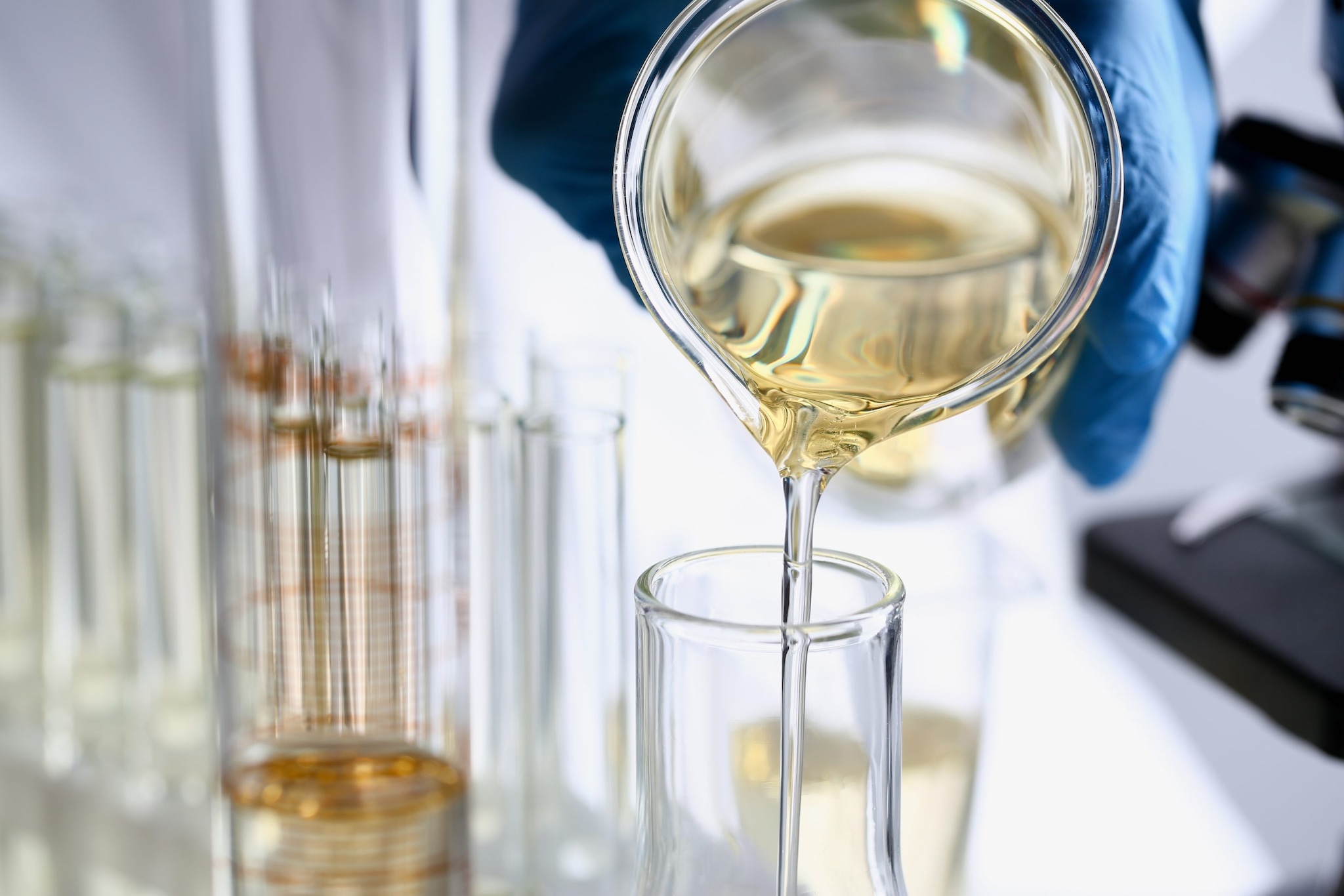 yellow liquid being poured out in a lab setting