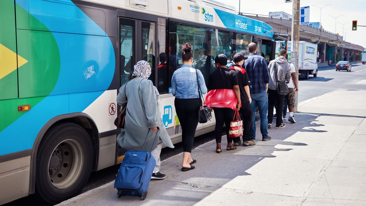 Adults waiting in line to get on the public bus