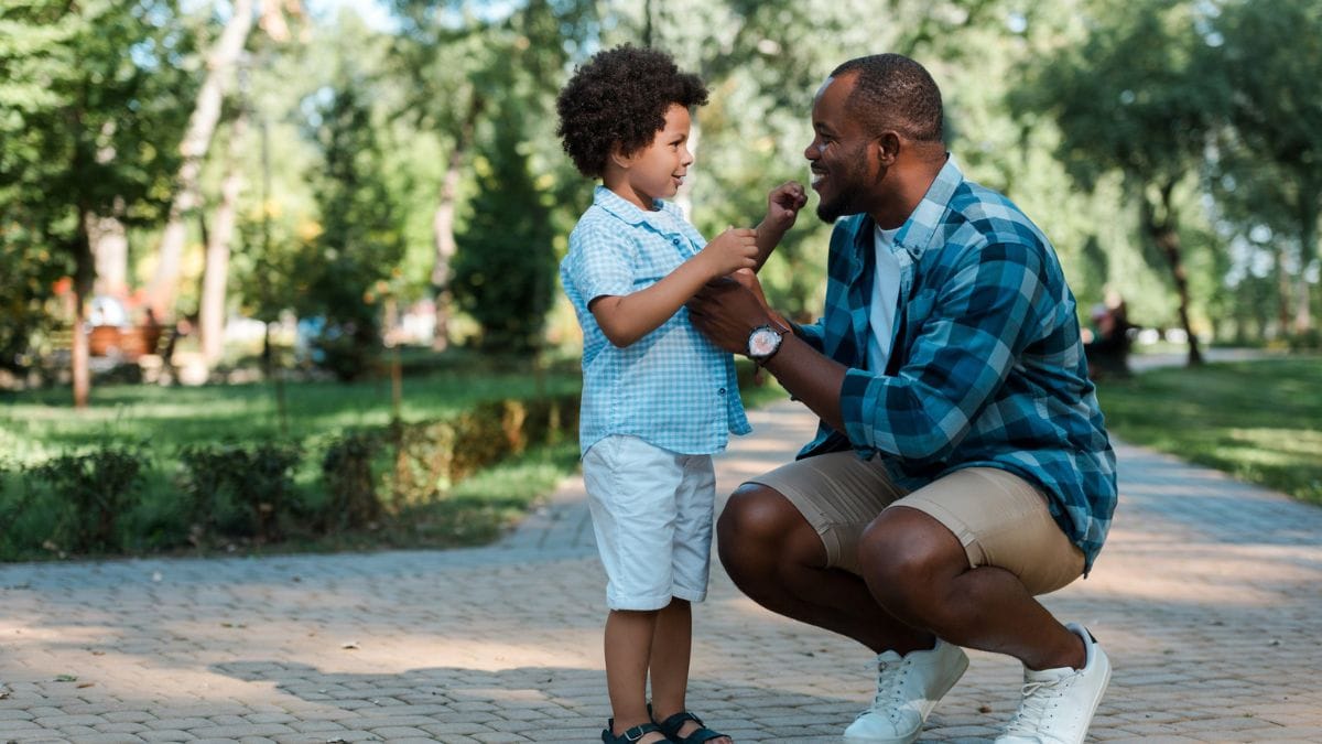 Male adult at eye level with young child depicting parenting tips