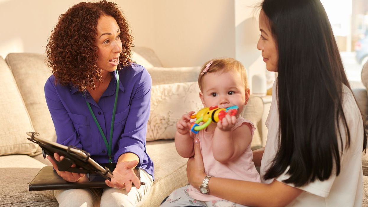 Doctor sharing information on a clipboard with a caregiver and her child