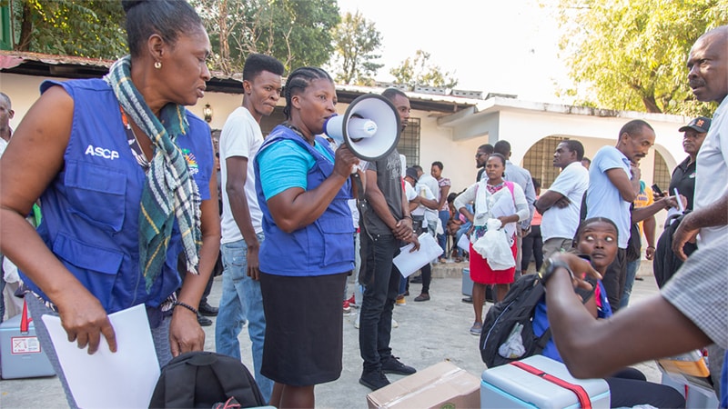 Community health workers in Haiti educate residents on cholera prevention and hygiene practices.