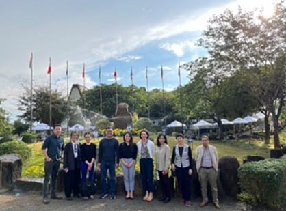 A group of people standing in front of a fountain