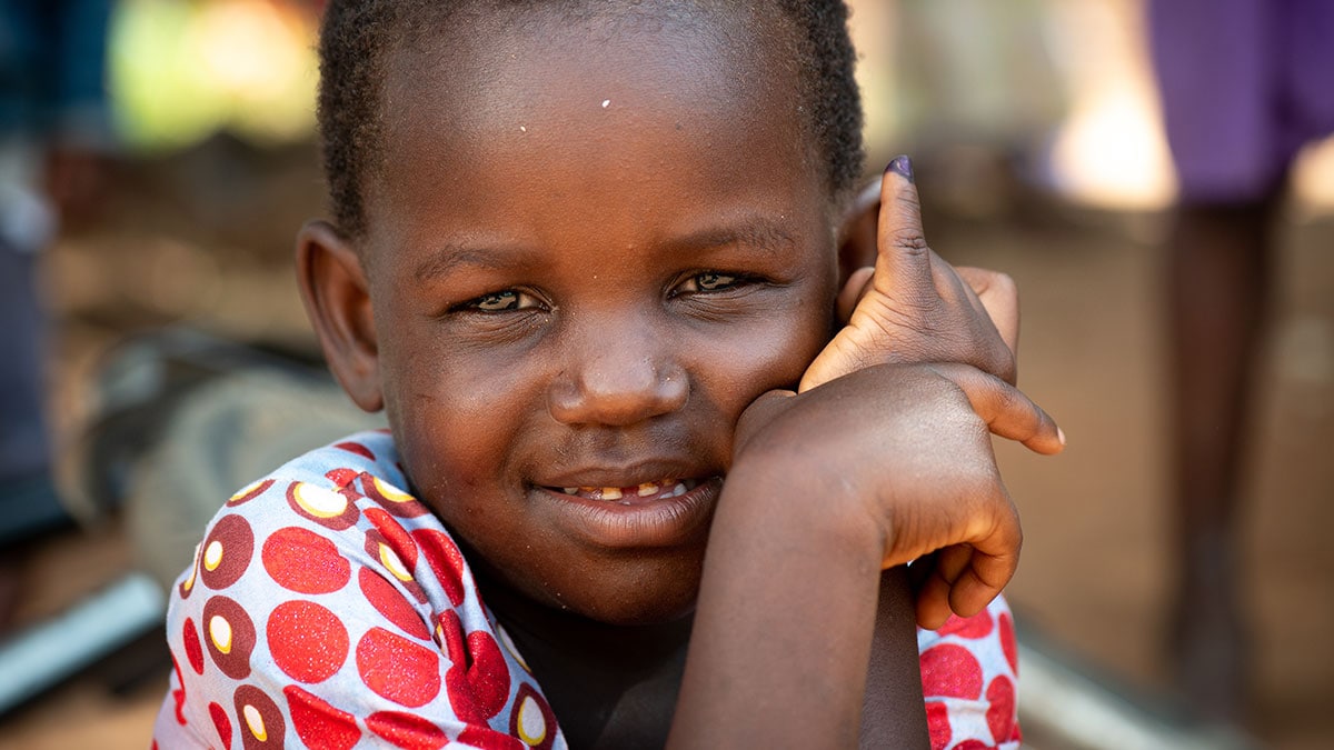 Girl displaying finger marked with ink.