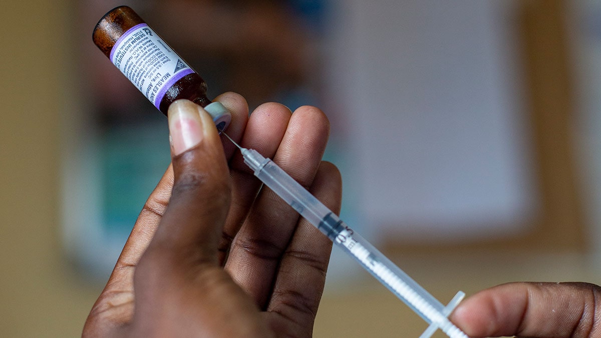 A pair of hands holding a syringe.