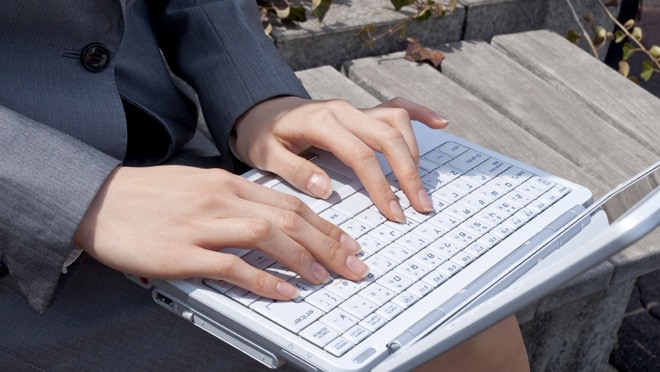 Person typing on a laptop computer.