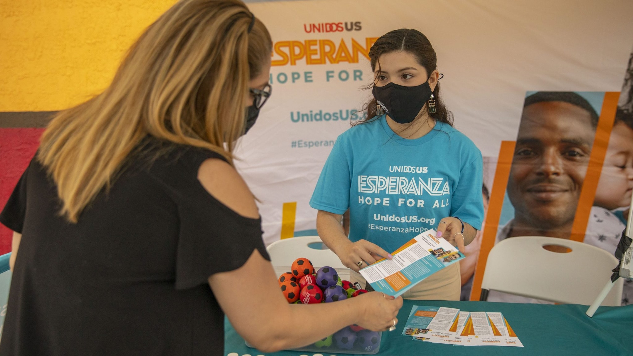 Esperanza Hope for All initiative volunteer sharing a brochure.