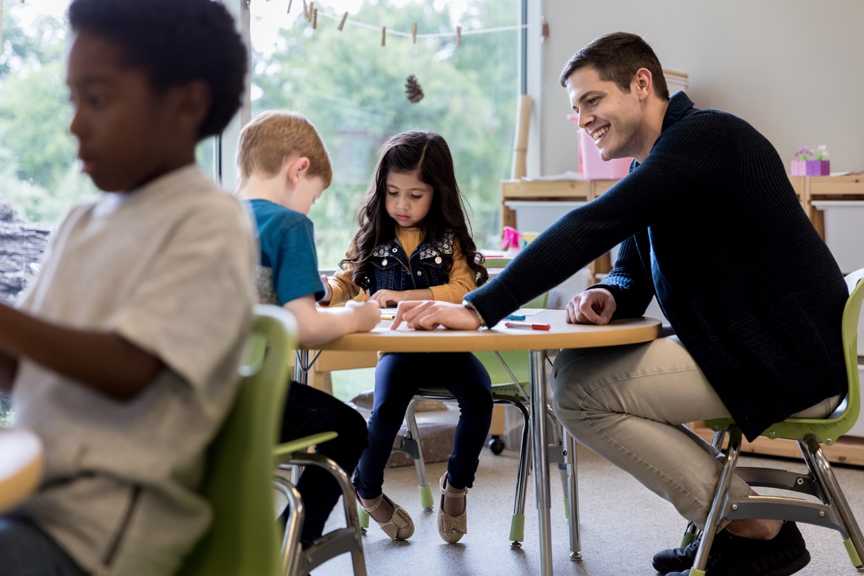 Parent helping students in classroom.