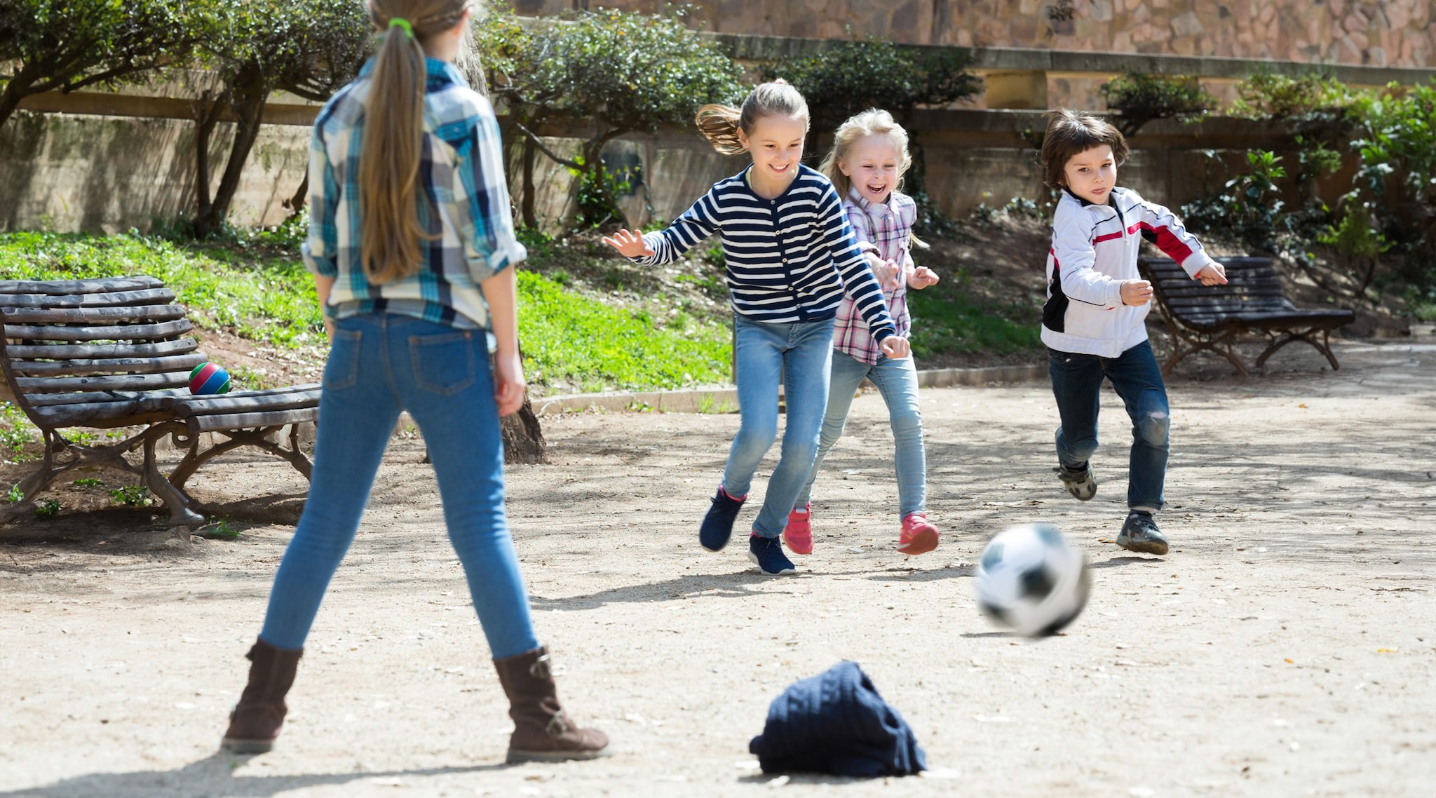 Young children kicking a soccer ball.