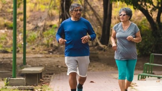 A couple walk through a park.