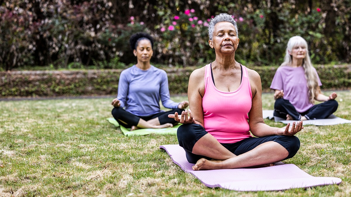 Senior women taking a yoga class in beautiful garden