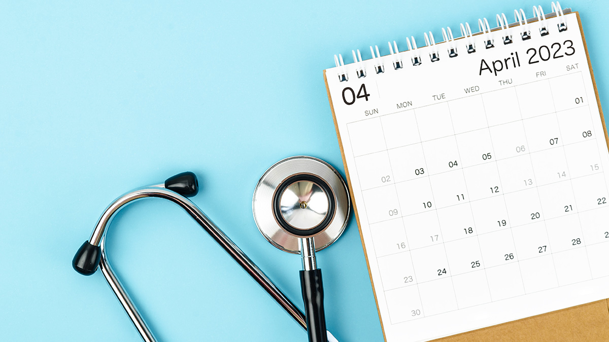 A stethoscope next to a calendar for April 2023