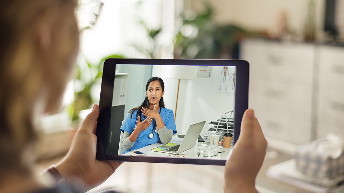 Person having a telehealth visit with a medical professional on their tablet.