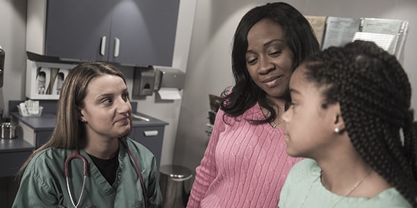 female doctor with mom and daughter.