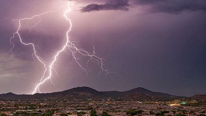 Lightning illuminating a dark, stormy sky.