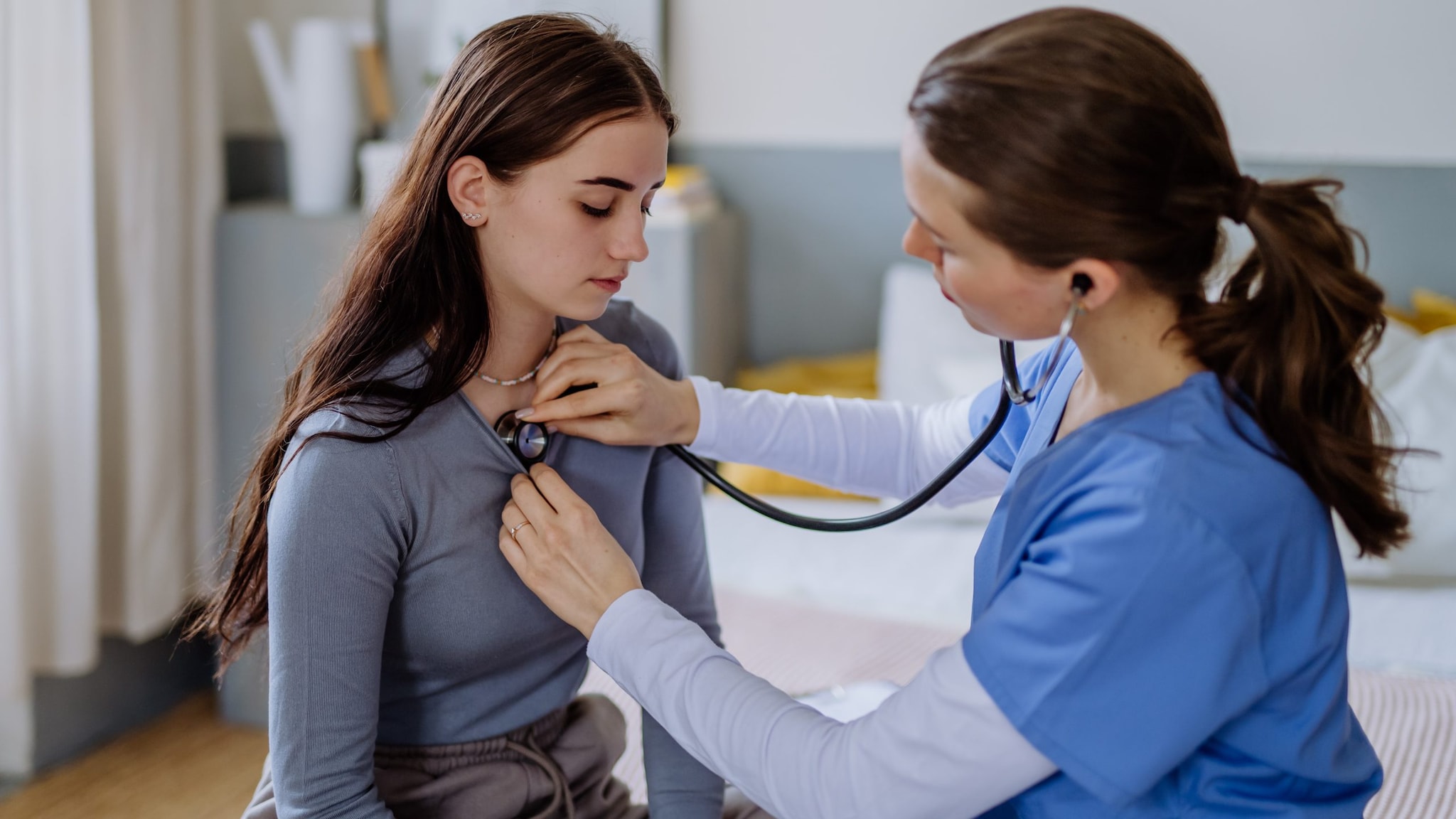 Doctor examining young female patient.