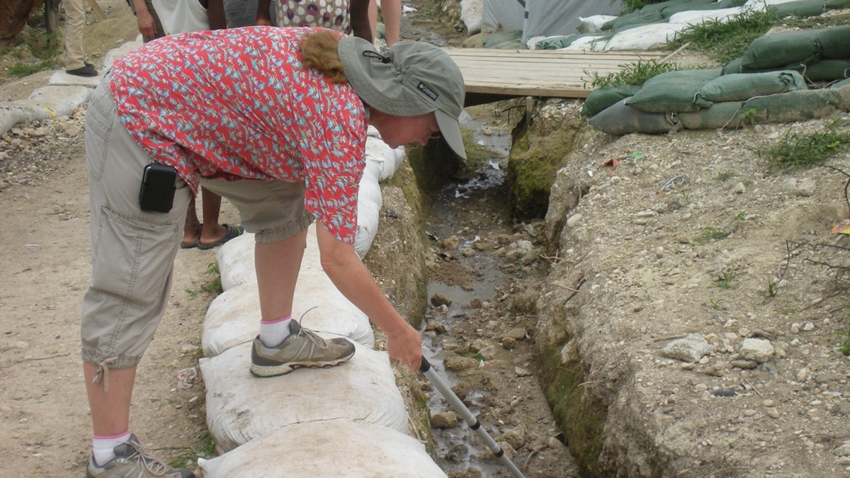 Photo showing a mosquito control professional collecting larvae.