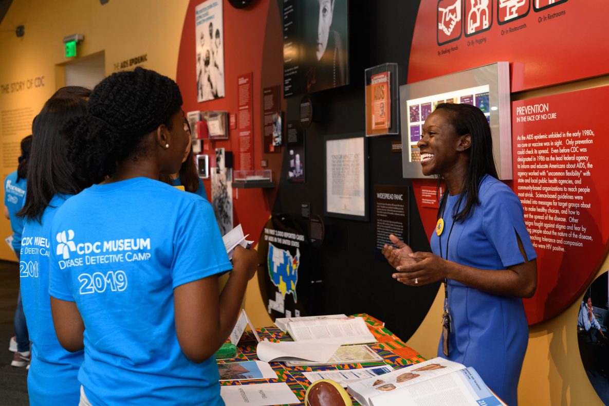 Three students speaking to adult