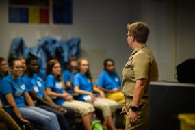 Group of students listening to an adult speak