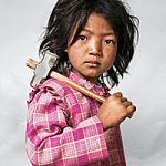 Photograph of a Nepalese child holding a hammer