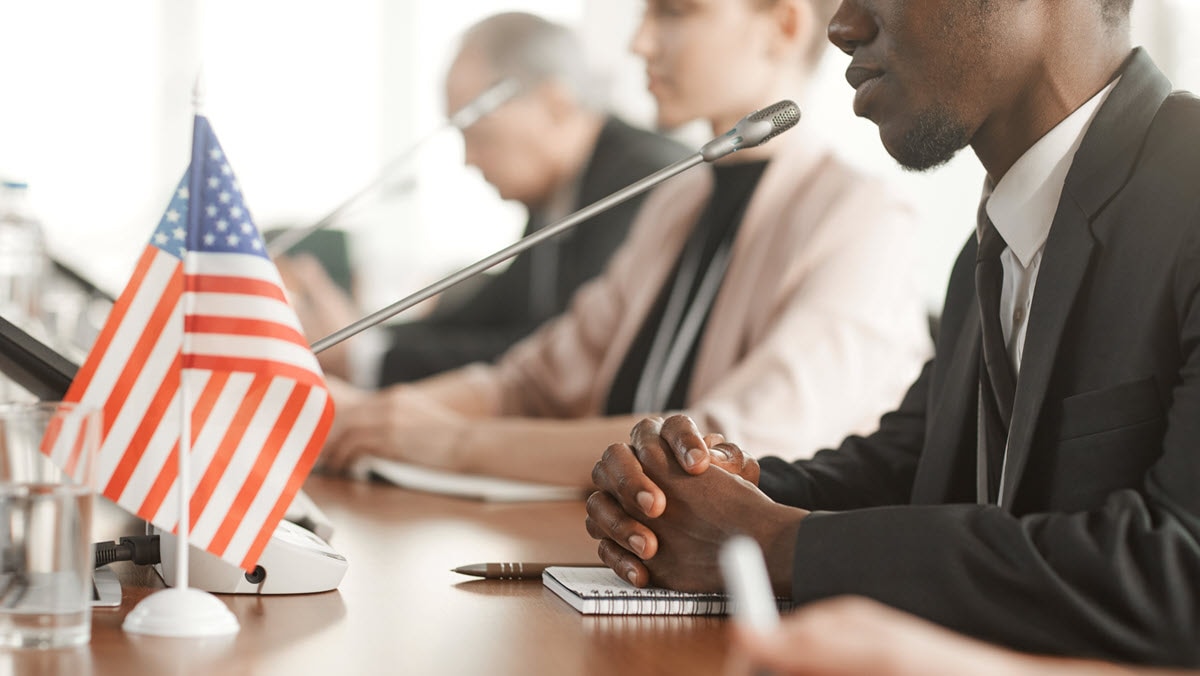 A man speaks into a microphone at a meeting.