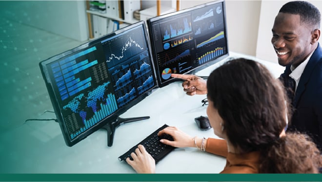 Two colleagues in an office sit at a computer and view data figures on two monitors. NCHS green dots overlay the image.