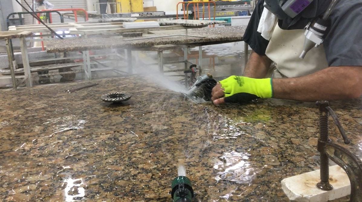 Worker conducts grinding task with a wetting method of combining water spray and sheet-wetting.