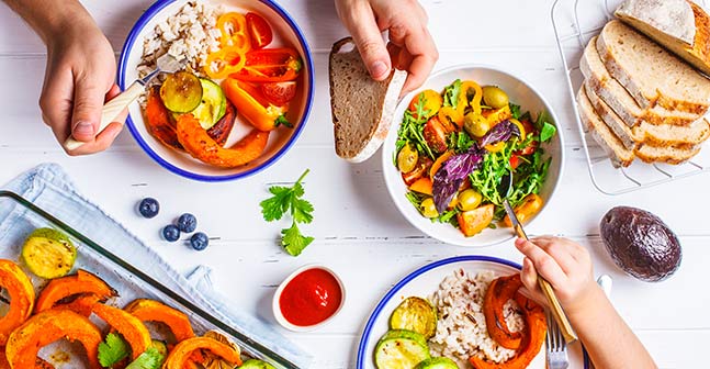 A picture of rice bowls that include a colorful array of veggies and herbs.