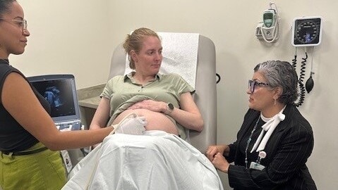 A pregnant woman gets an ultrasound while speaking to a female doctor