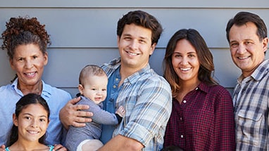 A picture of a young girl and baby surrounded by their parents and grandparents.