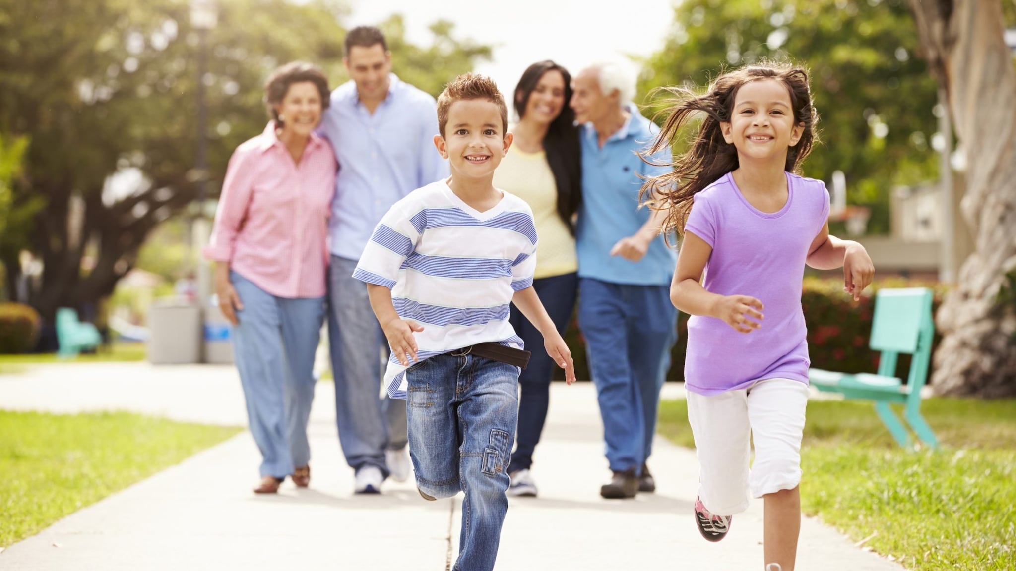 Family on a walk with 2 kids running in front of 4 adults.