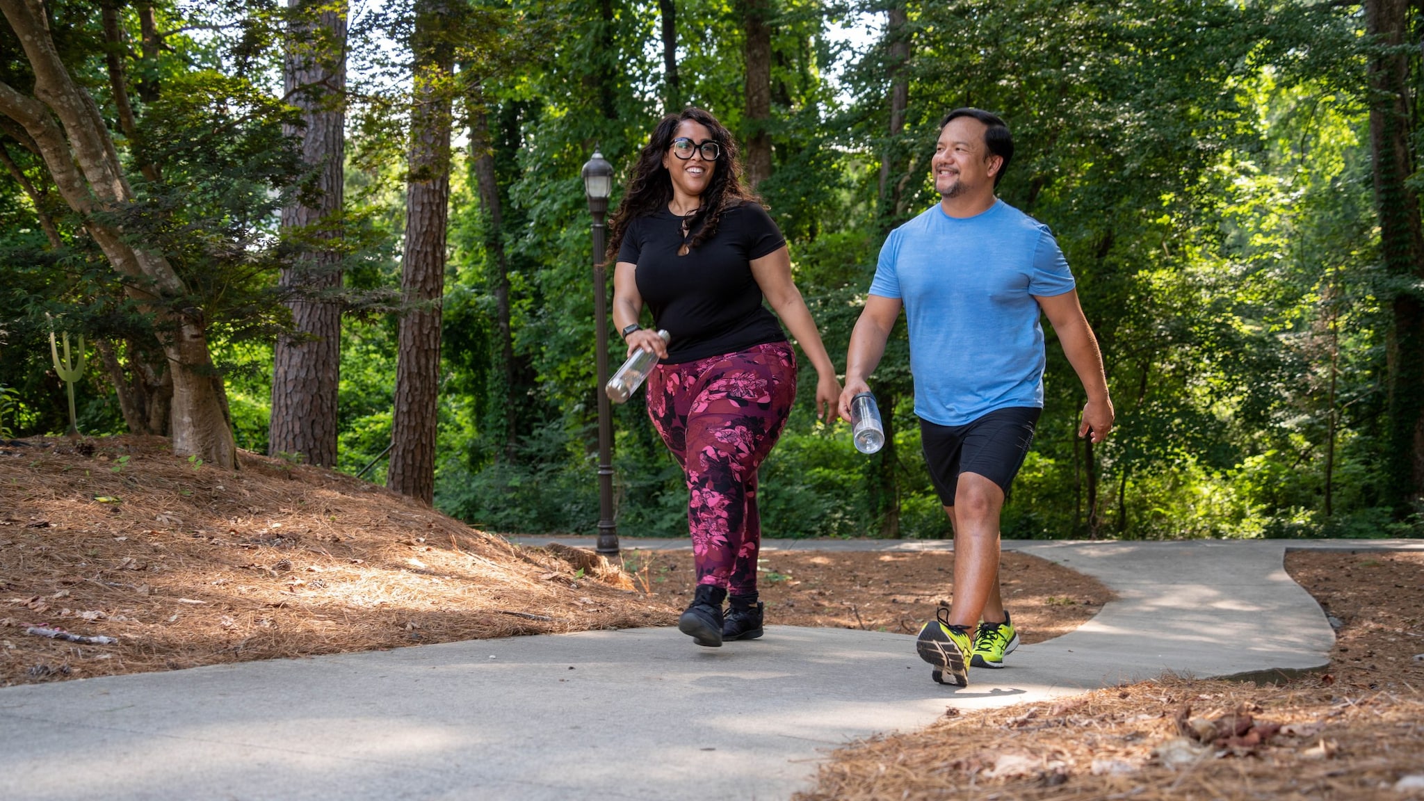 Two people walking on a path in the park