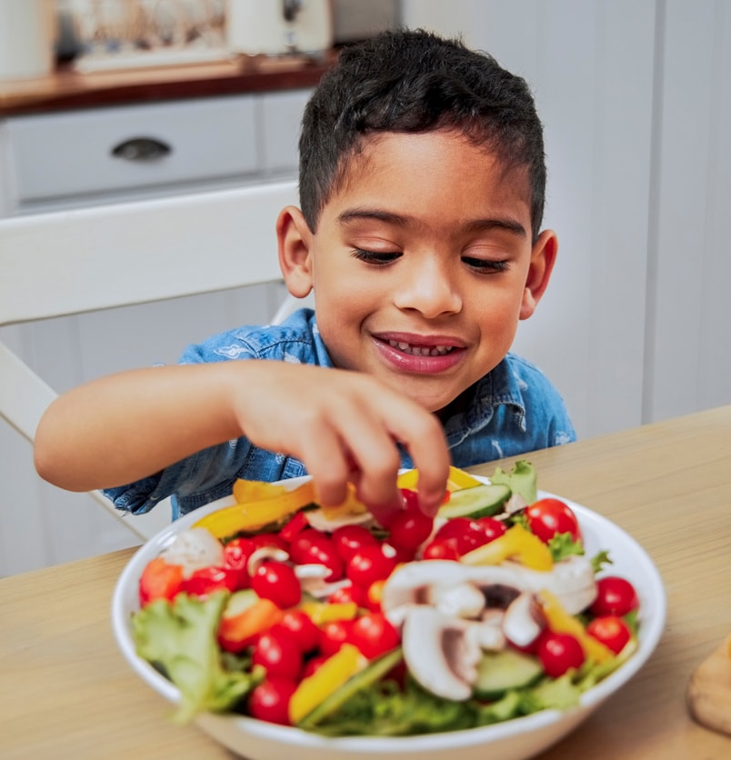 Little boy eating a salad