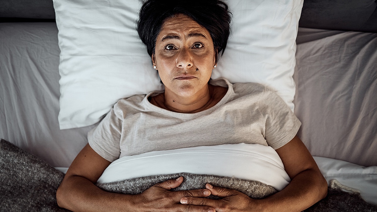 Woman lying wide awake in bed, unable to sleep.