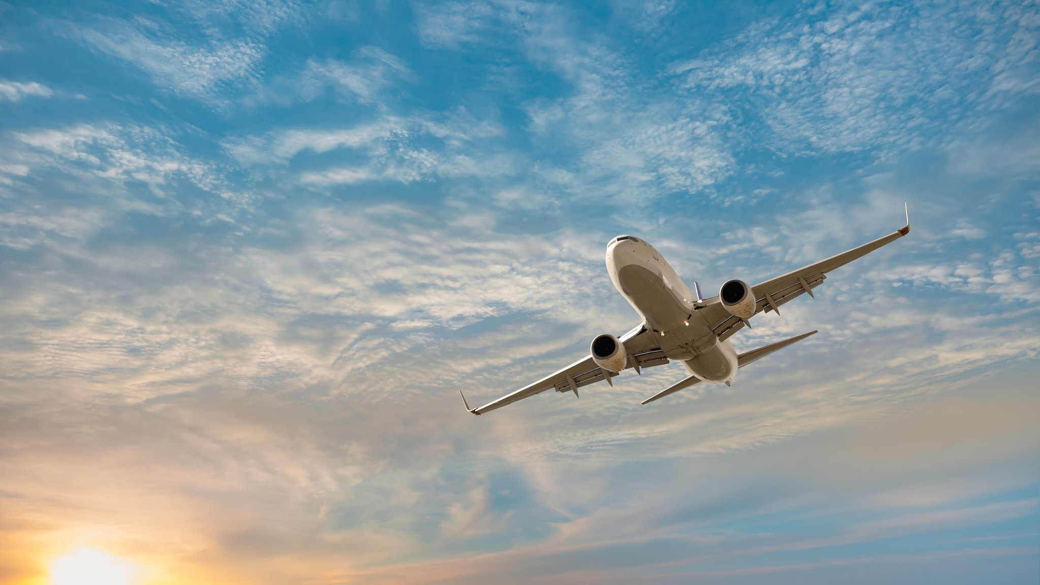 Airplane flying at sunset