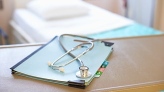 Stethoscope sitting on top of a stack of papers