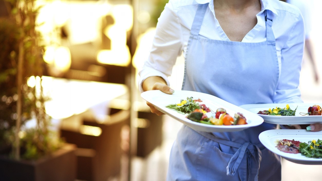 Waitress carrying plates of food.